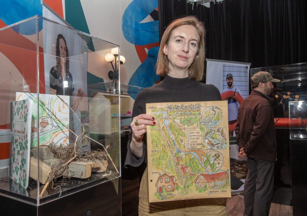 Photo of climate survivor Alice Irene holding a map of her garden.