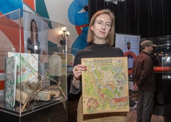 Photo of climate survivor Alice Irene holding a map of her garden.